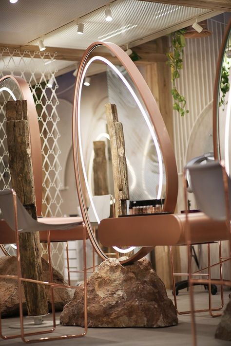 Agencement sur mesure pour salon de coiffure haut de gamme : Cet agencement unique fusionne nature et modernité pour offrir une expérience client remarquable dans un salon de coiffure premium. Chaque poste de coiffure est dominé par un miroir circulaire sur mesure, intégrant un éclairage LED discret qui améliore la visibilité tout en créant une atmosphère chaleureuse. Le cadre en métal couleur cuivre ajoute une touche de sophistication, tandis que le socle naturel en pierre brute ancre le design dans des éléments organiques. Les structures en bois brut, intégrées comme séparateurs et supports, rappellent un design rustique et authentique, offrant une esthétique apaisante et immersive. Les détails végétalisés et les matériaux texturés renforcent la connexion à la nature. L'ensemble, conçu avec des équipements de fabrication de pointe, garantit une qualité exceptionnelle, durable et idéale pour un environnement à fort trafic.