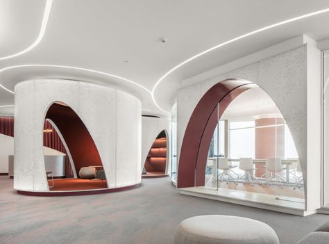 Custom Retail for a Coworking Space Chain. This installation highlights refined design expertise. Sculptural arches and perforated white panels create semi-enclosed alcoves, ideal for distinct workspaces. The interplay of elegant curves seamlessly integrates into the layout, offering functional zones while promoting an immersive and fluid aesthetic. The integrated lighting, in soft and sinuous lines, enhances the architectural forms and guides the eye through the space. The optimization of volumes balances privacy and sociability, creating an adaptable and attractive environment for users.