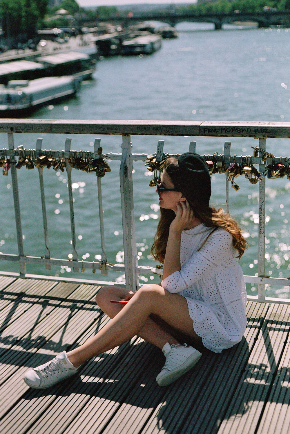 girl sitting on a wooden bridge in Paris captured on 35mm film