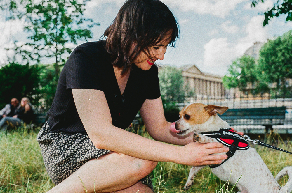 cute photo of a girl playing with dog in Paris on 35mm film