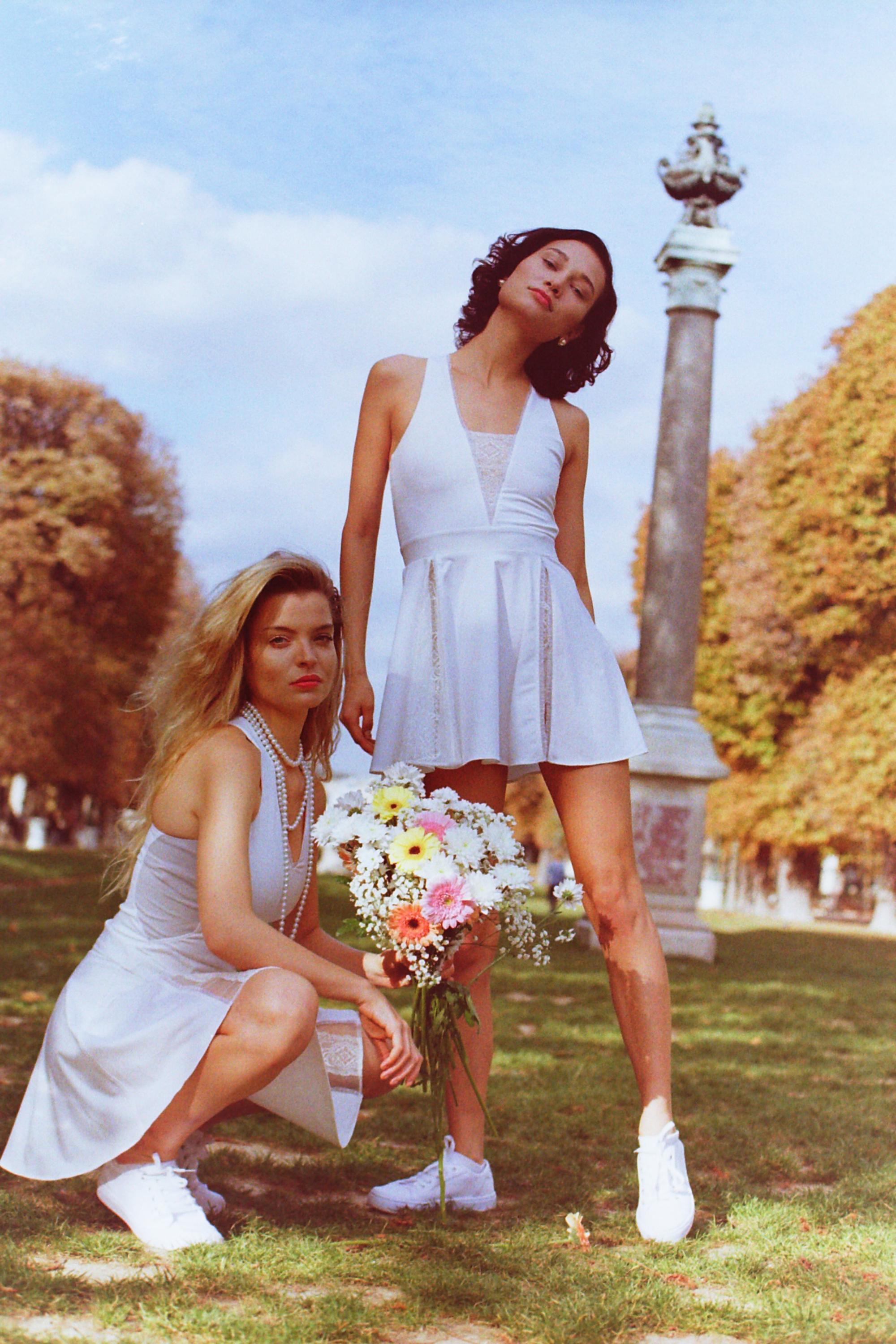 Models posing together in Thaber's retro tennis outfits, blond model holding flowers, shot on film by Paris fashion photographer Anya Parsley