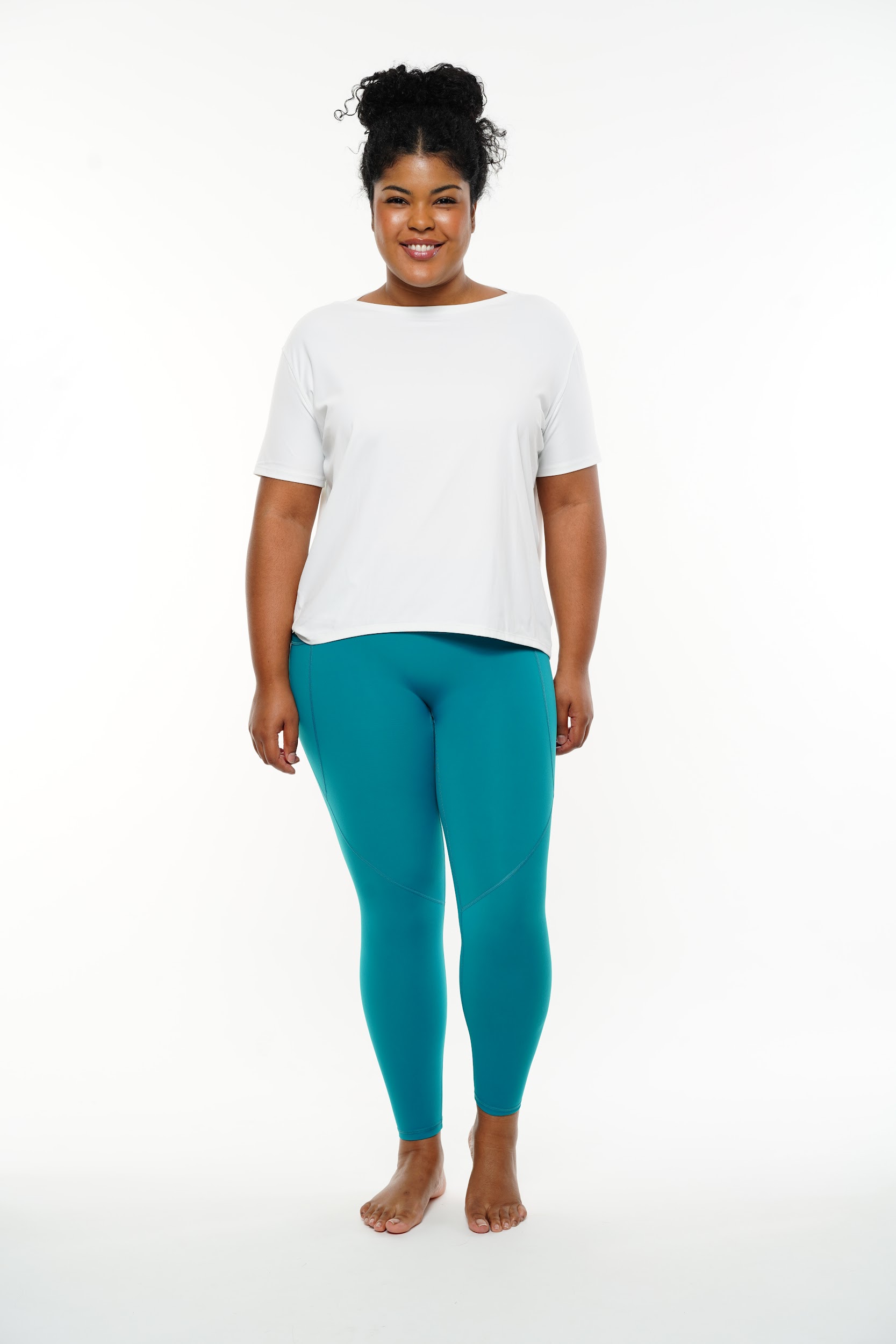 Plus-size model posing in sports outfits on a white background captured by fashion photographer Anya Parsley