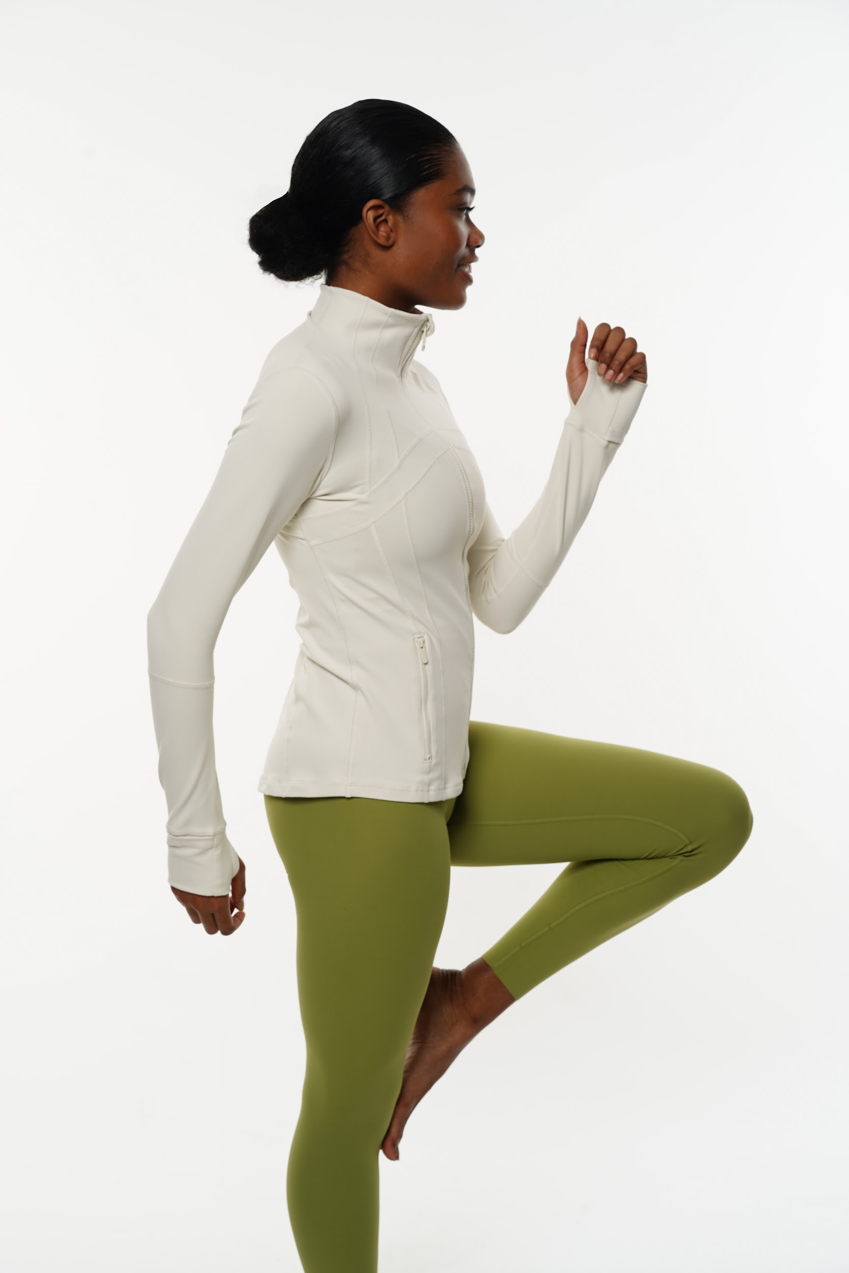 Side profile of model in sleek workout gear under studio lights.