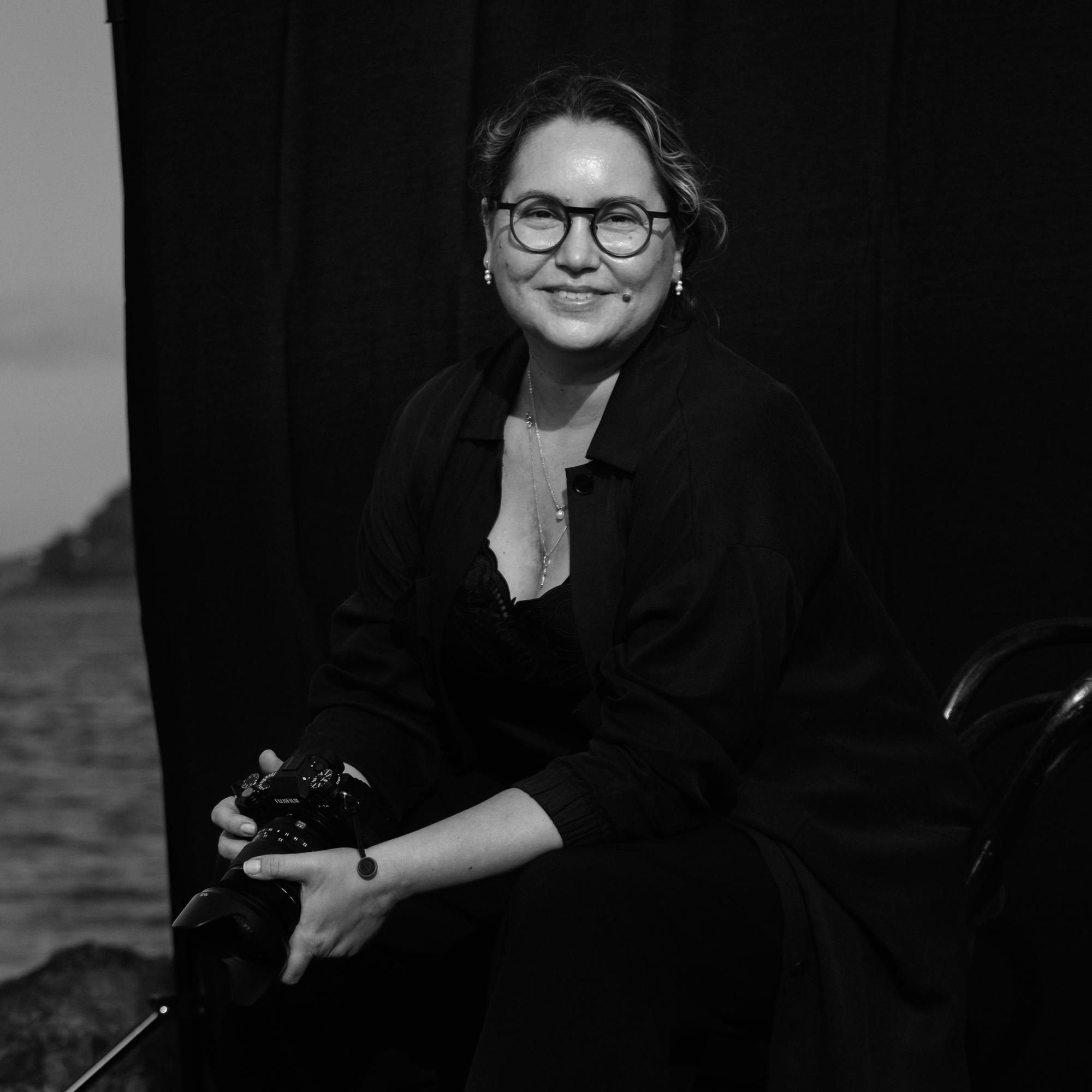 fotograf sitter under jobboppdrag med fotokamera i hender.
