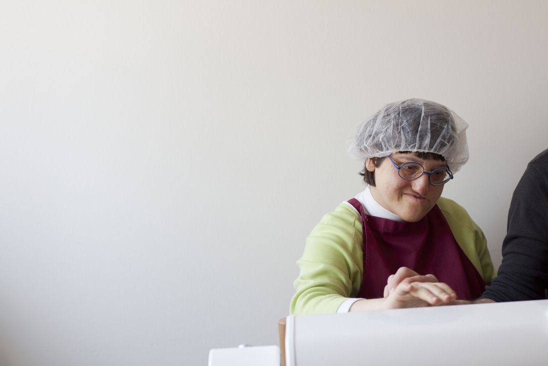 Eine Frau arbeitet im Behindertenwerkstatt Lebenshilfe Nürnberg, der Lehrer hilft ihr. Foto