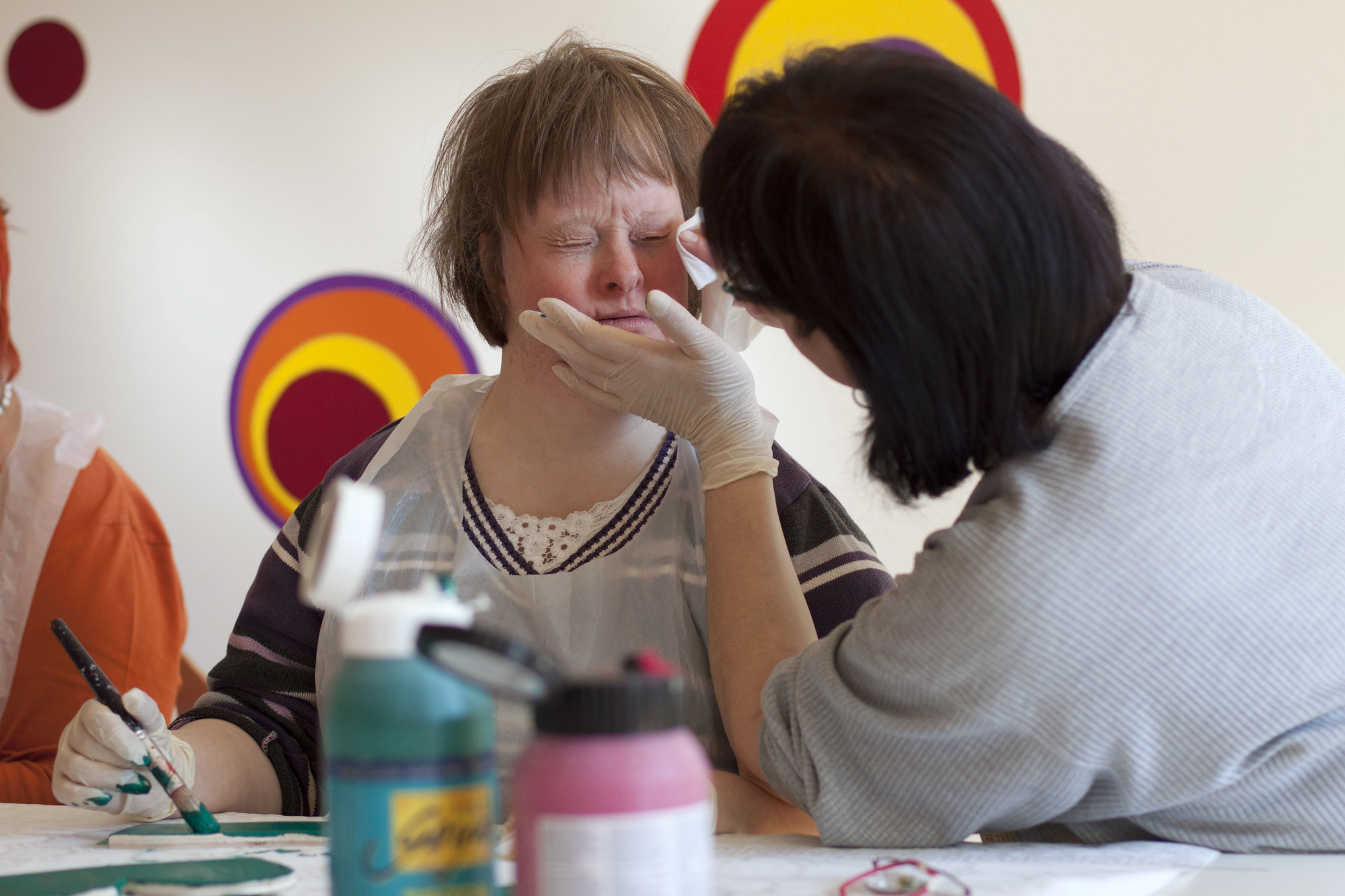 Kunstunterricht im Behindertenwerkstatt Lebenshilfe Nürnberg. Frau mit Downsyndrom malt. Foto