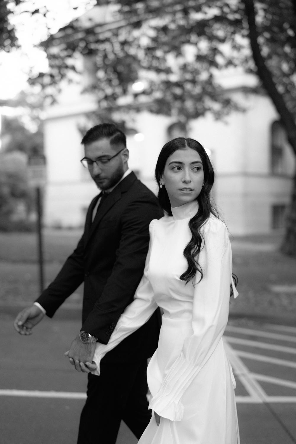 Engaged couple walking hand in hand, black and white