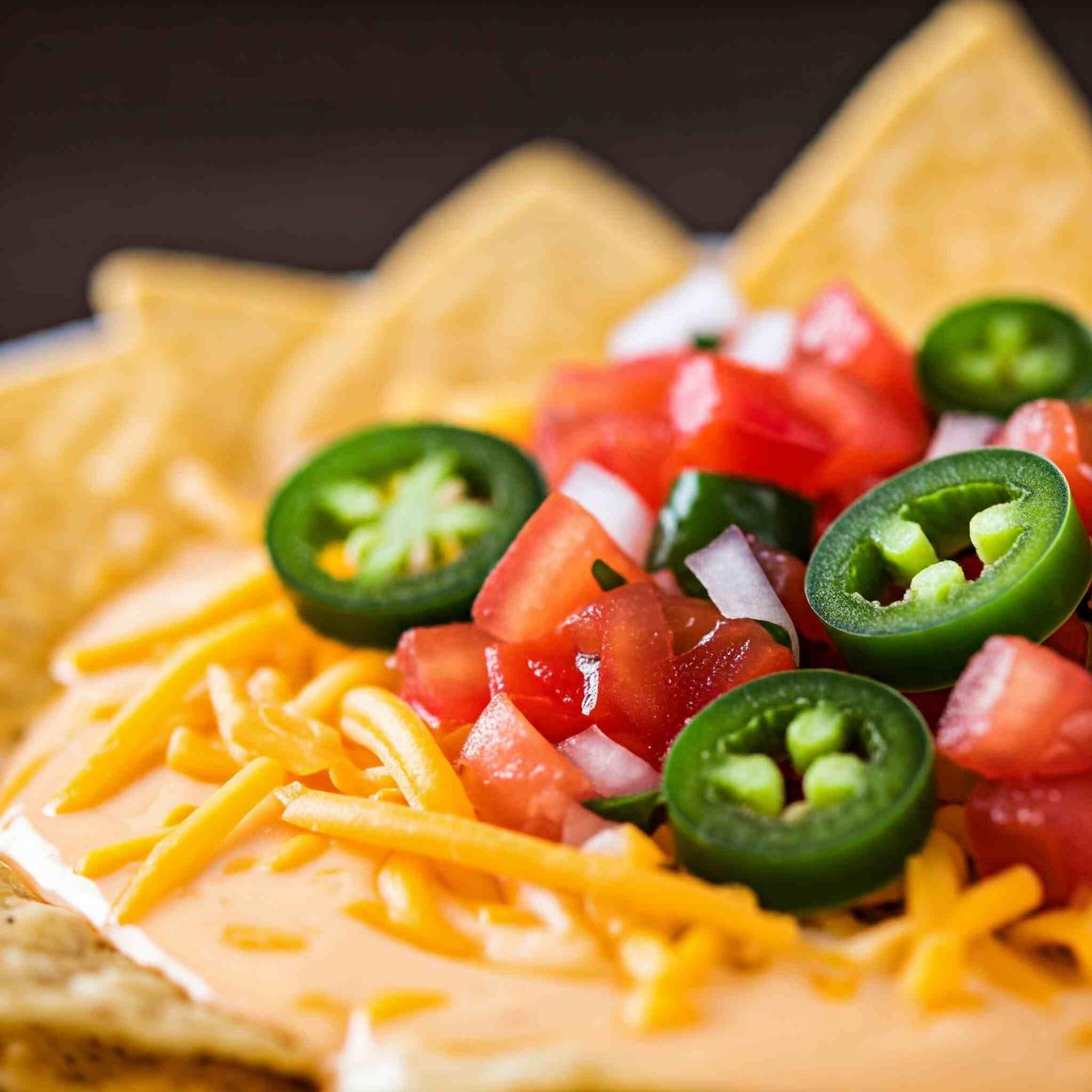 A delicious and hearty Taco Bell Breakfast dish featuring crispy tortilla chips topped with creamy cheese sauce, fresh pico de gallo, and spicy jalapenos.