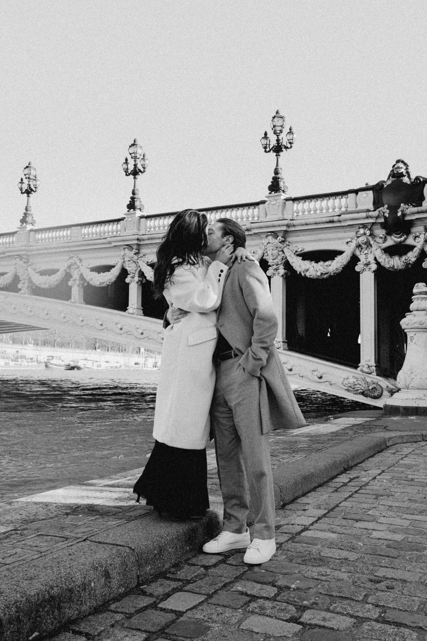 cinematic and vintage engagement photo of a couple kissing in Paris