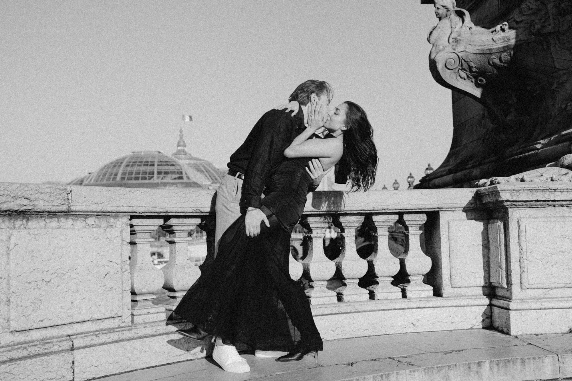 Black and white engagement photo with play of light and shadow on the bridge Alexandre III in Paris