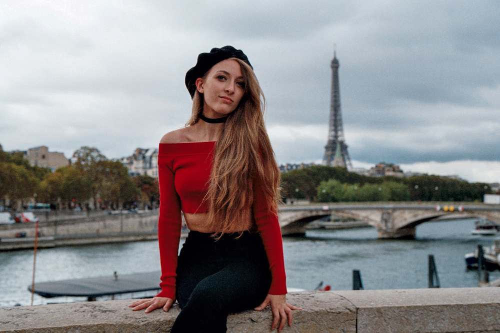 Elegant portrait of woman with beret by the Seine river, Paris backdrop