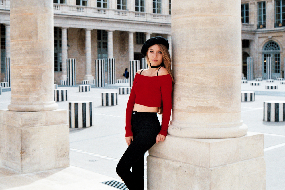Serene portrait of woman in beret in hidden garden of Palais Royal in Paris by Anya Parsley