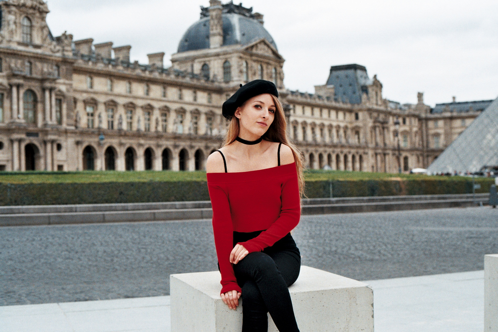 timeless portrait of a woman sitting in front of the Louvre Museum wearing a French beret by photographer Anya Parsley