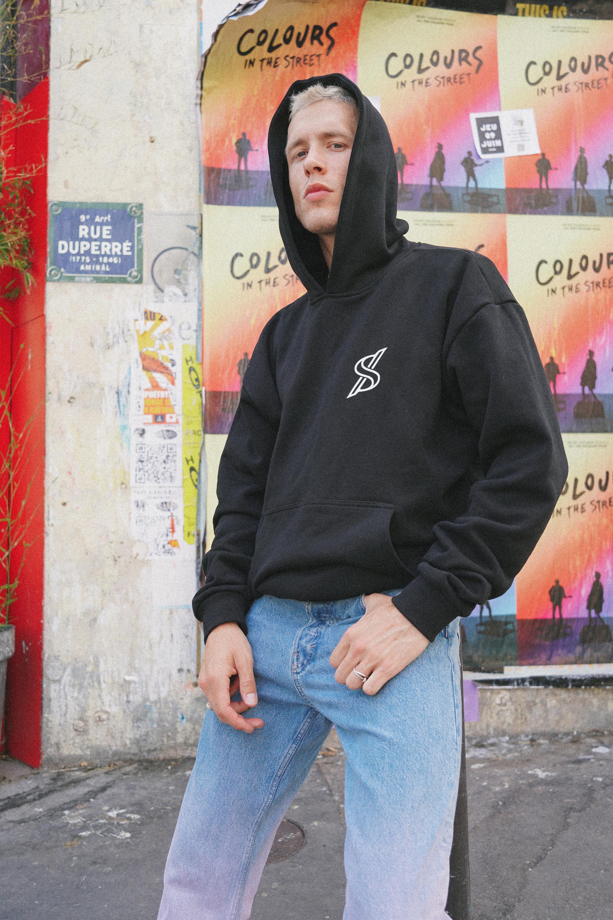Male model posing with SNATCH hoodie against graffiti backdrop in Pigalle