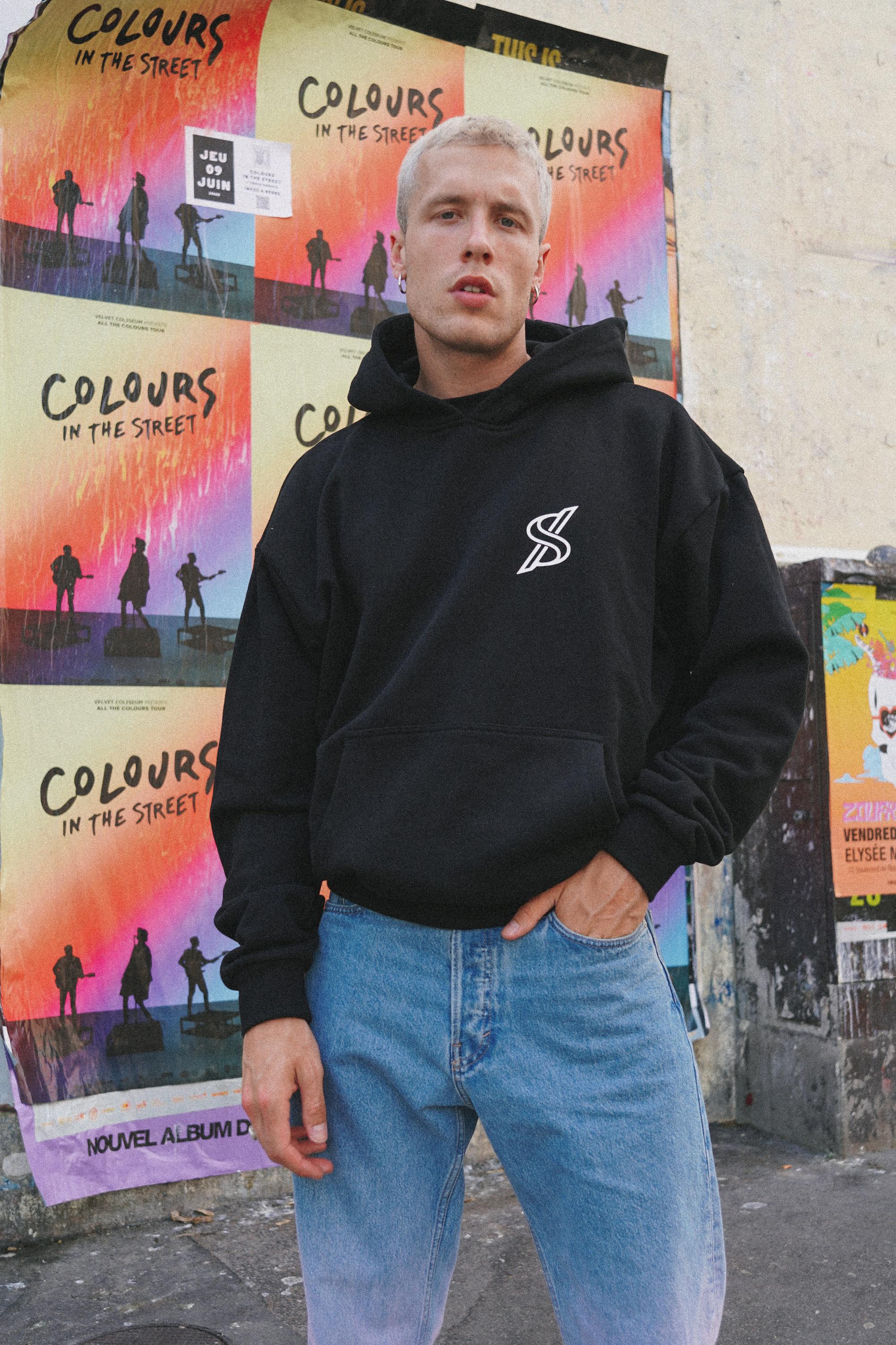 Male model posing with SNATCH hoodie against graffiti backdrop in Pigalle captured by Paris fashion photographer