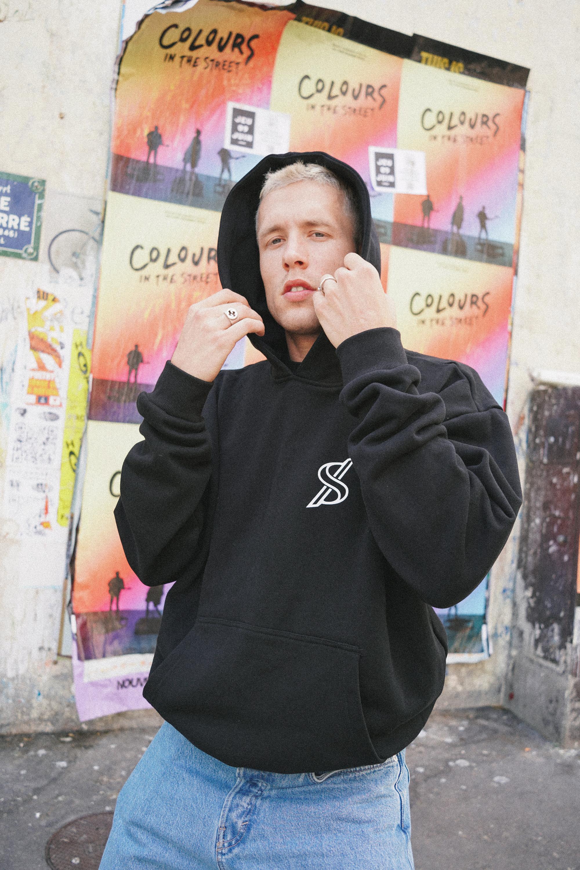 Male model posing with SNATCH hoodie against graffiti backdrop in Pigalle