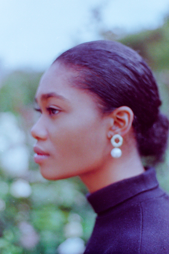 Pearls jewelry displayed on a model against lush garden backdrop during a lookbook photoshoot in Paris