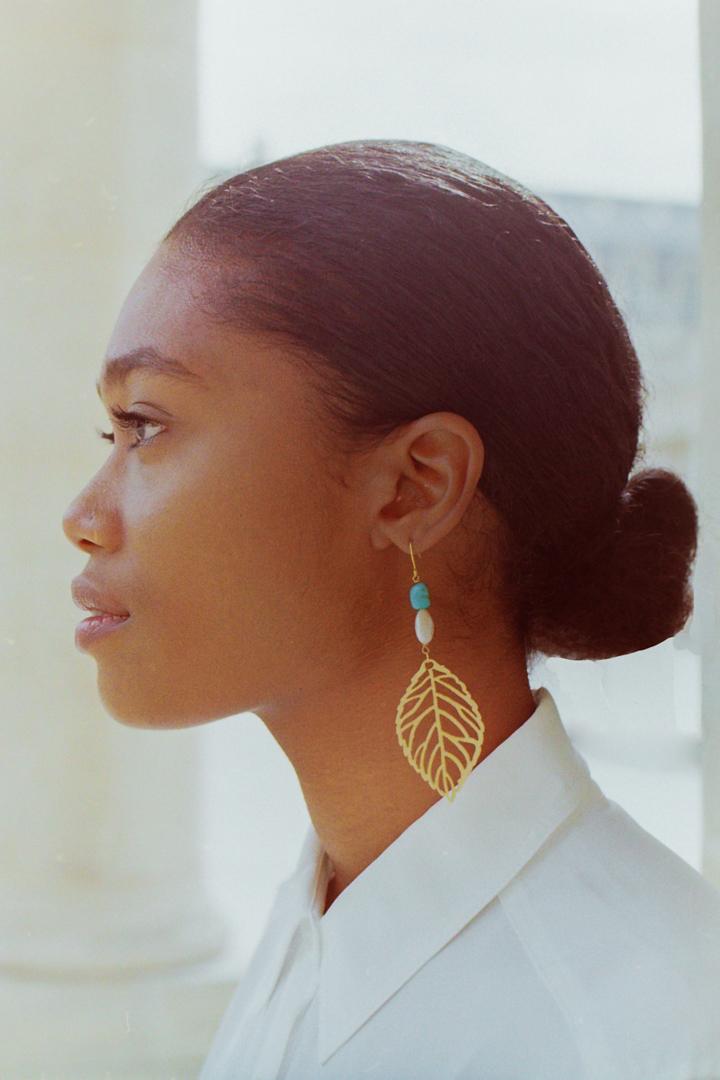 Model posing against historic architecture in Palais Royal Garden, wearing Gina Gant Pearls for a lookbook shoot in Paris