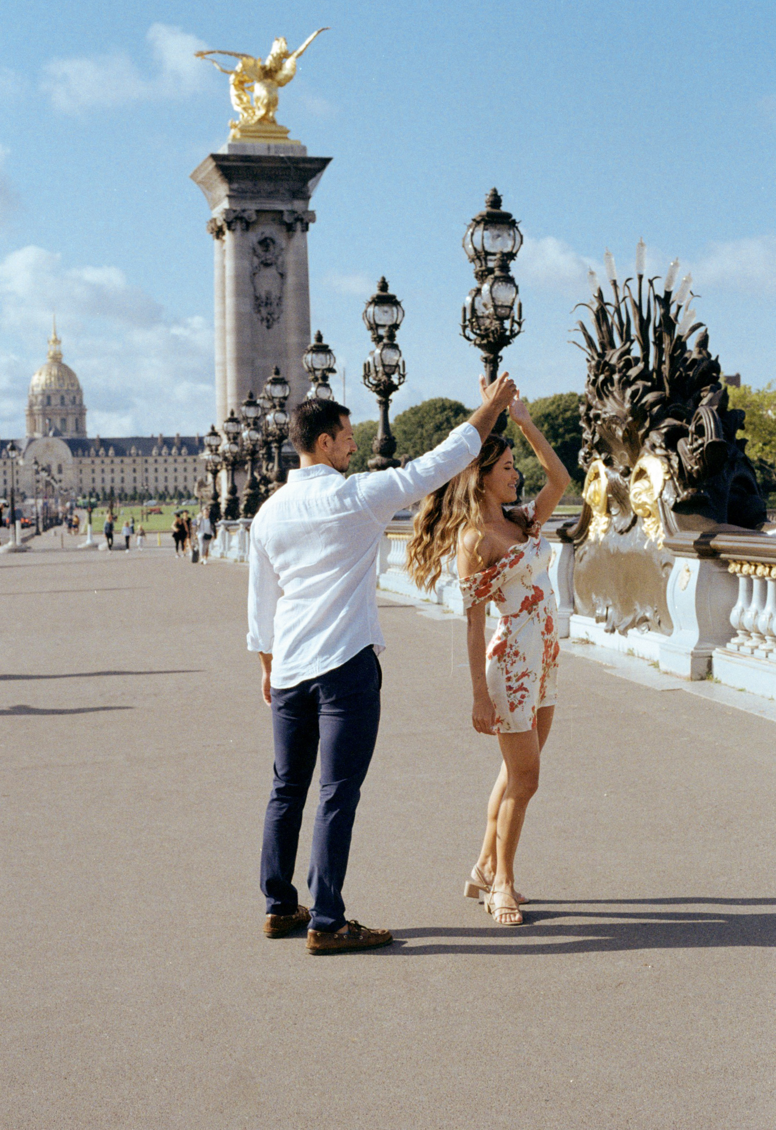 couple dancing on the bridge Alexandre III during their engagement photo session in Paris